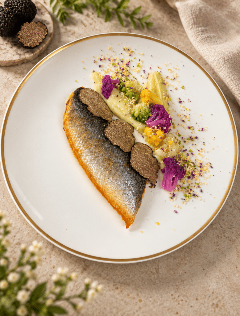 Poisson dressé à l’assiette avec légumes et lamelles de truffe
